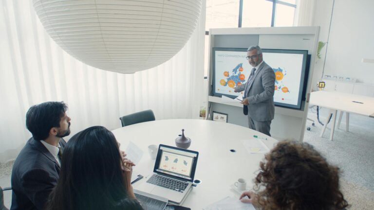 Professional team engaged in a business presentation in a modern office setting.
